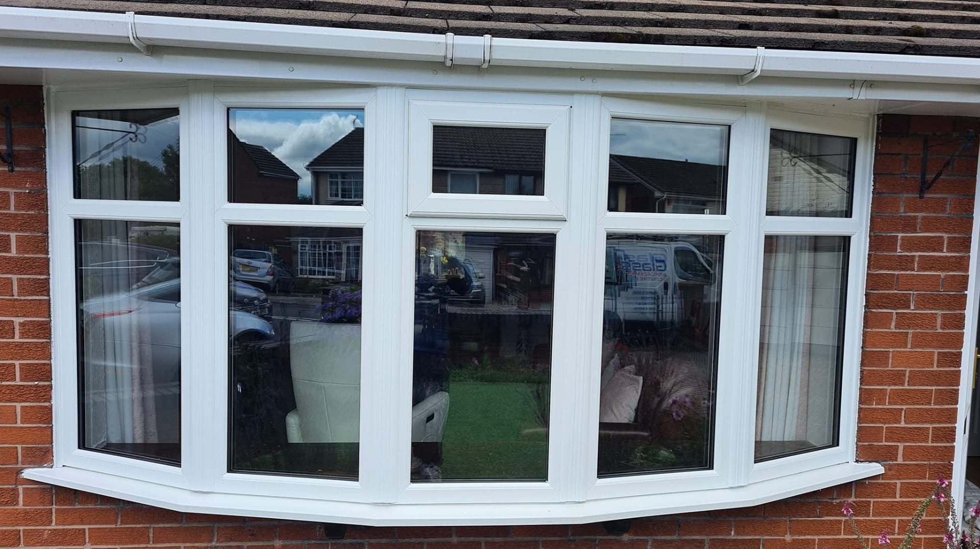 White uPVC bow window with clear replacement double glazed units on a brick bungalow